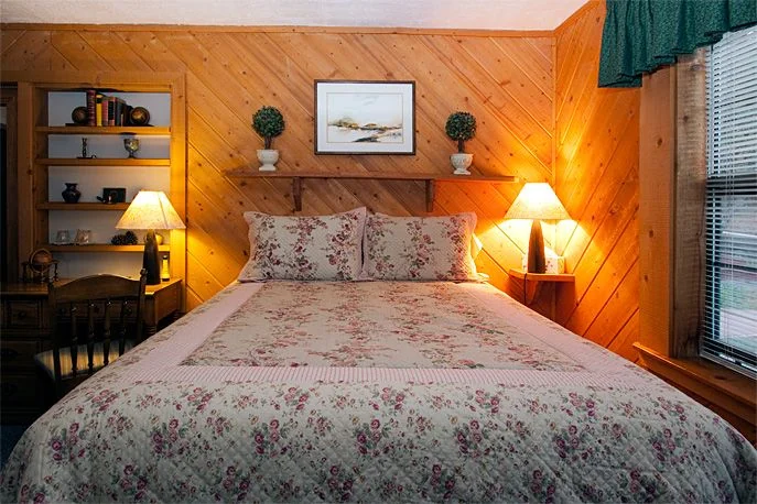 Knotty-pine walls and a queen bed in the Pine Room at Country Sunshine Bed & Breakfast